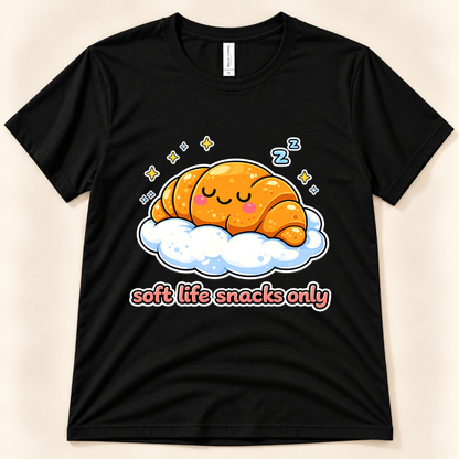 Black Bella Canvas 3001 kawaii croissant shirt featuring a smiling sleeping pastry on a cloud, yellow stars, blue Z symbols, and Soft Life Snacks Only saying from New Chapter Tees, a California small business.