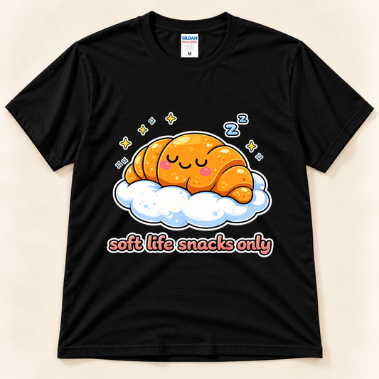 Black Gildan 5000 croissant graphic tee featuring a kawaii sleeping pastry with pink cheeks, fluffy cloud, stars, and Soft Life Snacks Only lettering from New Chapter Tees, a California small business.