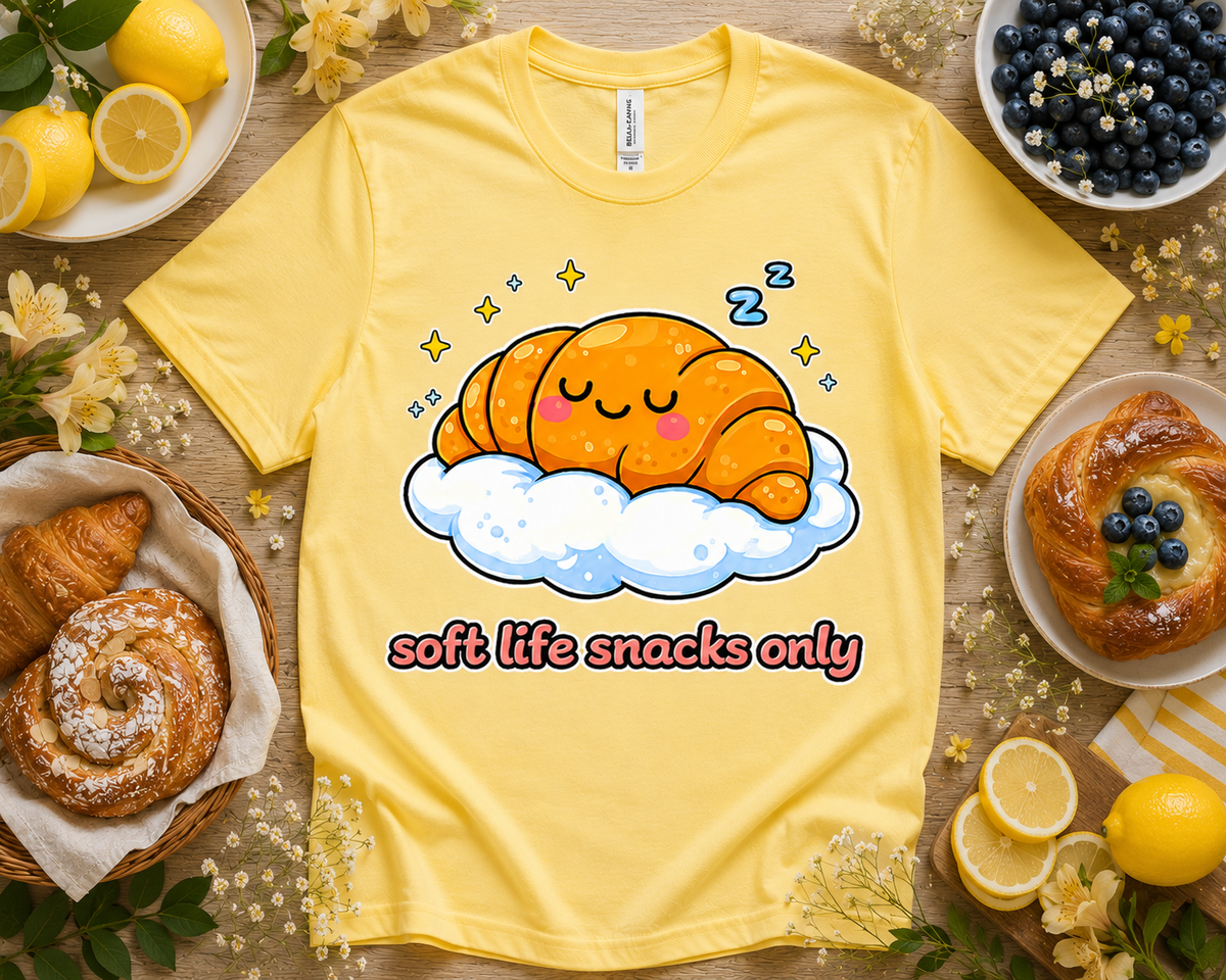 Yellow Bella Canvas 3001 Soft Life Snacks Only croissant graphic tee bright bakery themed flatlay