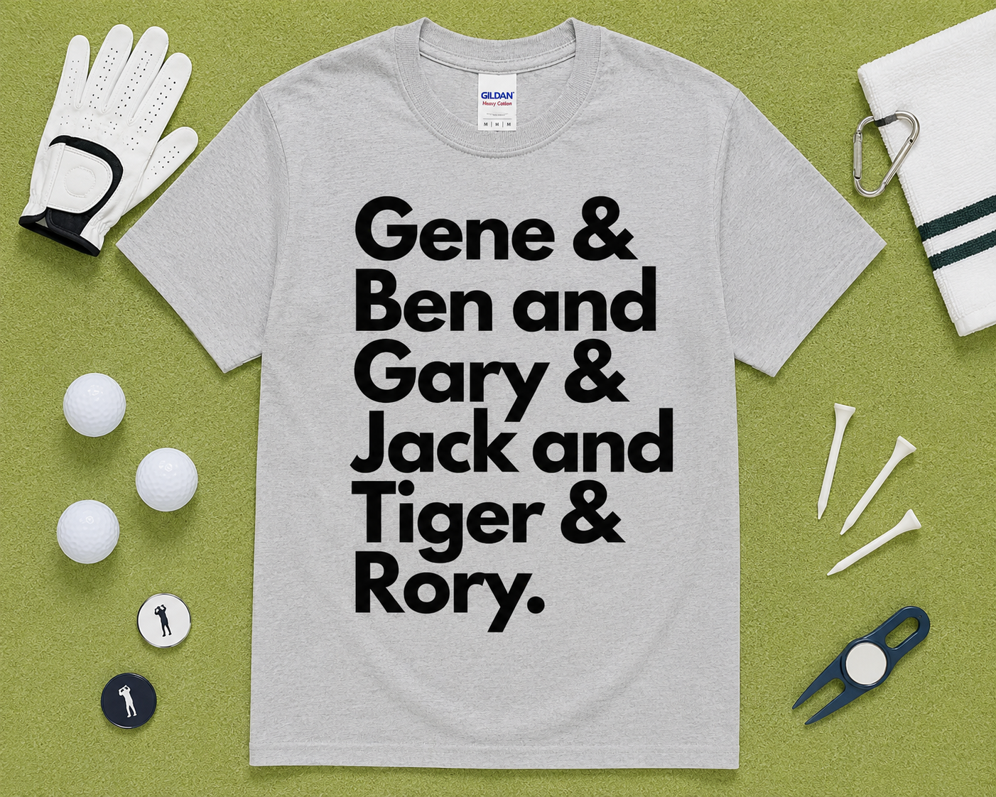 Sport Gray Gildan 5000 funny golf shirt flatlay featuring Gene Ben Gary Jack Tiger Rory graphic with golf accessories on light green grass, golfer gift idea, unisex golf clothing for golfers across the USA.
