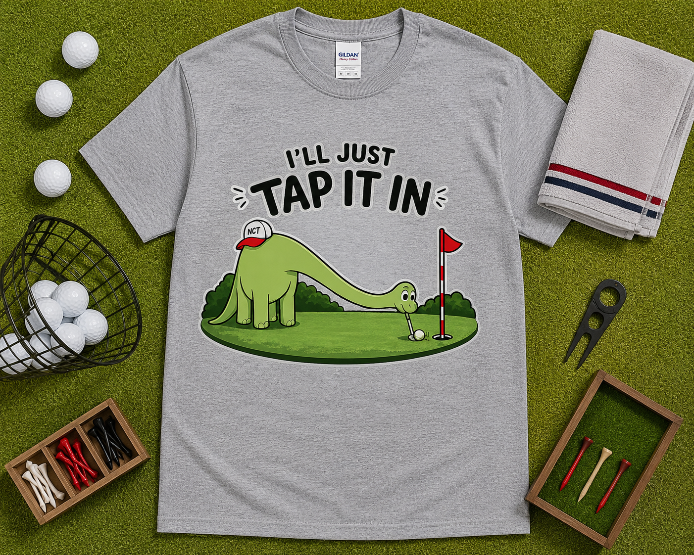 Sport Gray funny golf shirt flatlay featuring Ill Just Tap It In dinosaur golfer graphic on golf themed grass background comfortable golf lover gift USA
