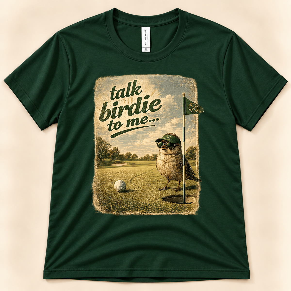 Forest Bella Canvas 3001 Talk Birdie To Me graphic tee featuring a funny bird golfer beside a golf ball and putting green from New Chapter Tees, a California small business.