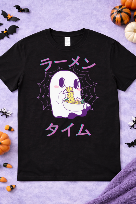 Kawaii ghost ramen graphic tee on black shirt featuring cute spooky ghost eating noodles with chopsticks, Japanese ramen text, Halloween anime foodie design flatlay with pumpkins and bats