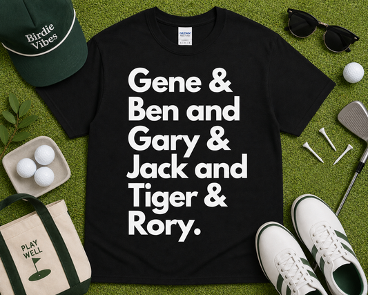Career Grand Slam Golf Tee black shirt featuring Gene Ben Gary Jack Tiger Rory typography golf graphic with golf accessories flat lay styling