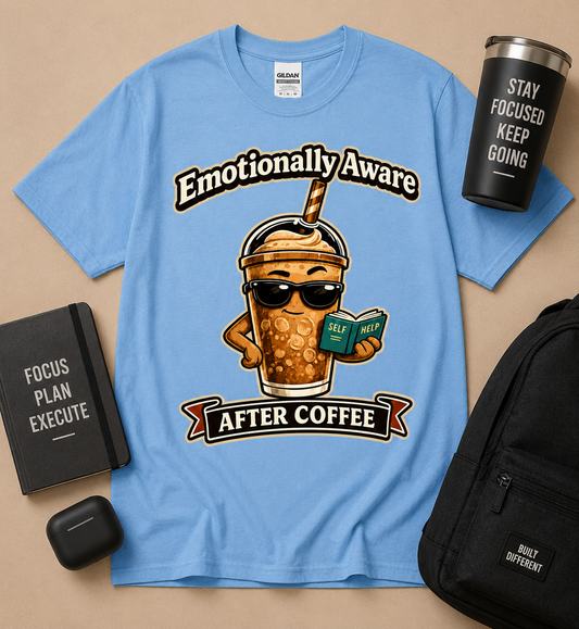 Emotionally Aware After Coffee funny coffee lover graphic tee on Carolina Blue Gildan shirt featuring iced coffee character reading self help book for caffeine lovers