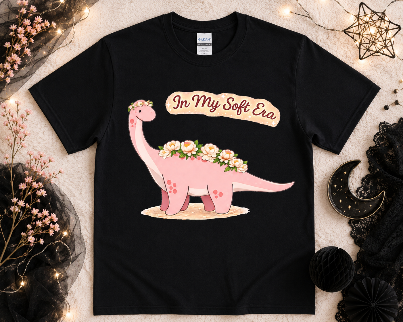 Floral dinosaur soft era graphic tee on black Gildan shirt with feminine flower flatlay styling