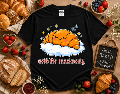 Black Gildan 5000 kawaii bakery croissant graphic t shirt featuring soft life snacks only design styled with bakery props pastries and berries for trendy foodie streetwear and cozy aesthetic apparel shoppers in California
