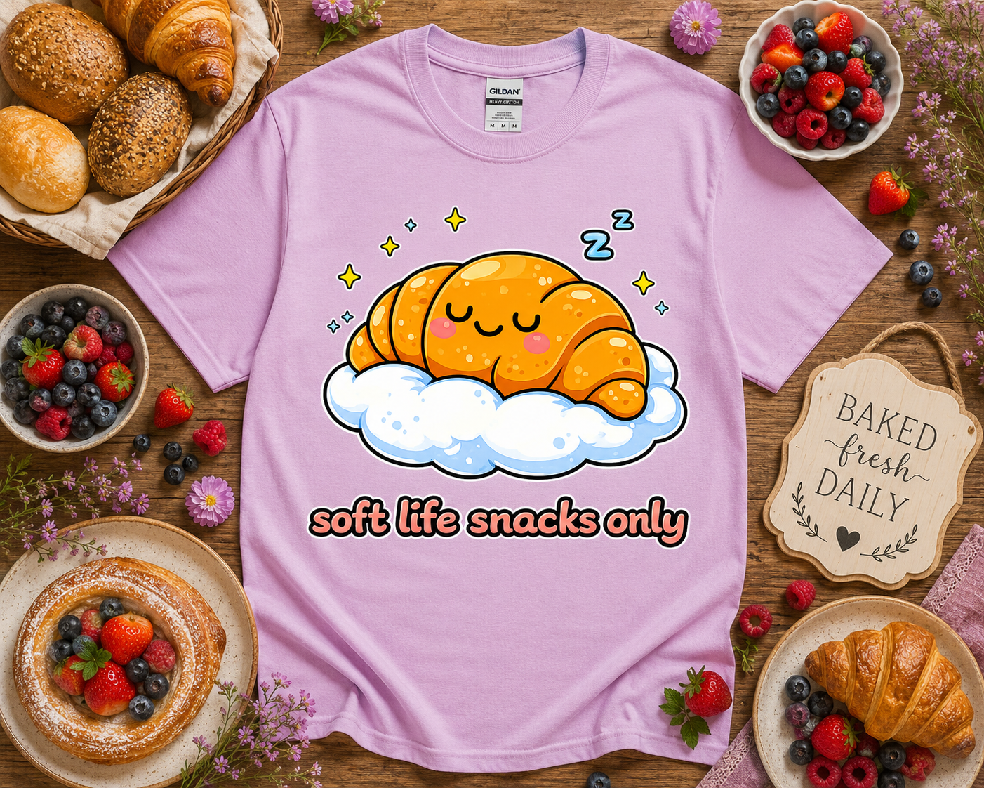 Orchid purple bakery aesthetic t shirt with kawaii sleepy croissant graphic and soft life snacks only phrase on Gildan 5000 styled with boutique bakery props for cute foodie apparel shoppers and gift buyers in Los Angeles