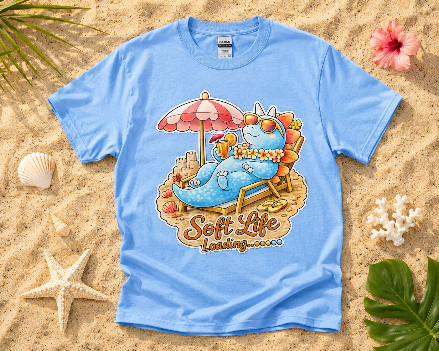 Soft Life Stegosaurus dinosaur graphic tee on Carolina Blue Gildan shirt with tropical beach vacation flatlay relaxing summer style