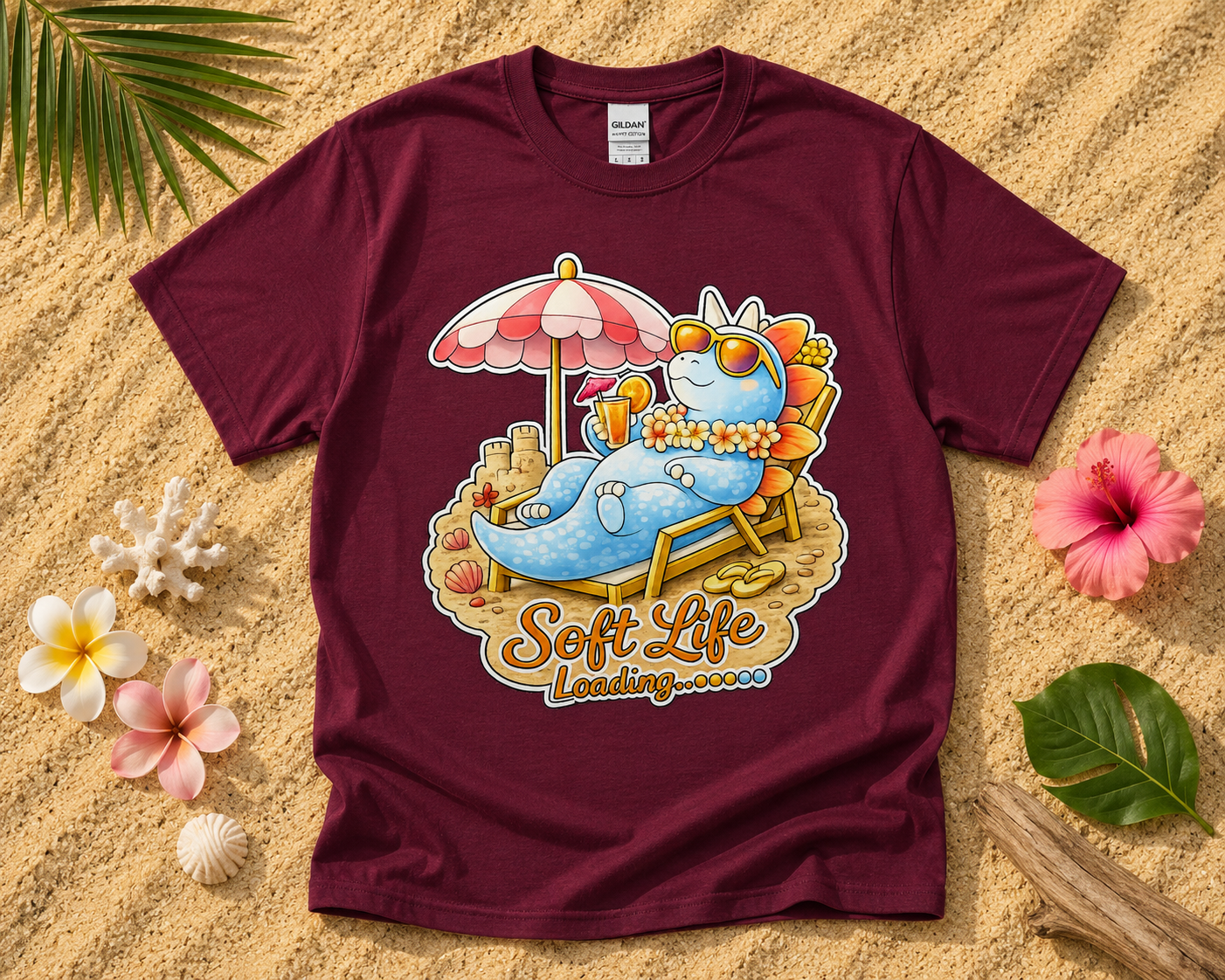 Soft Life Stegosaurus dinosaur graphic tee on maroon Gildan shirt with tropical beach flatlay cute dinosaur vacation graphic apparel