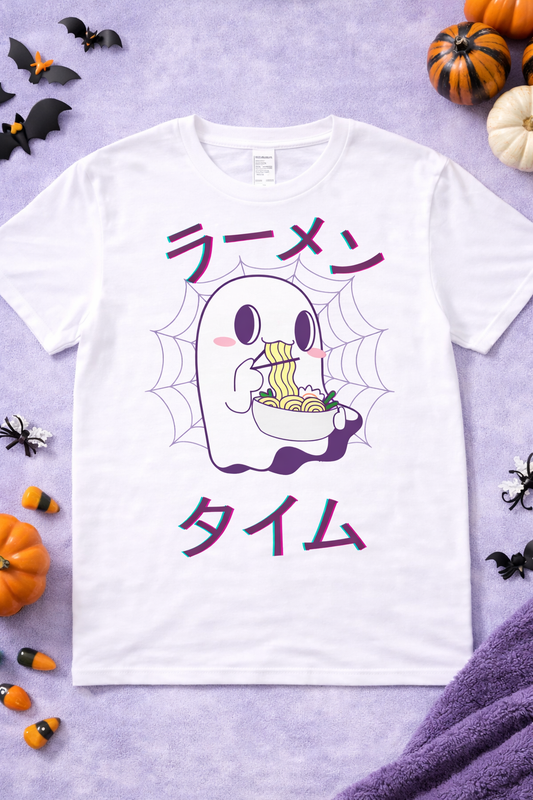 Kawaii ghost ramen graphic tee on white shirt featuring cute spooky ghost eating noodles with chopsticks, Japanese ramen text, Halloween anime foodie design flatlay with pumpkins and bats