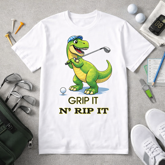 Funny dinosaur golf shirt with Grip It N Rip It text and T Rex golfer graphic on black and white tee flatlay with golf accessories